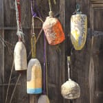 Painting of buoys hanging on a wood fence