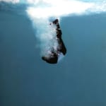 Man in business suit falling underwater
