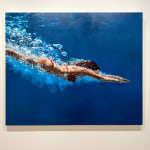 Woman in a red bikini diving through blue water