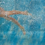 Girl reaching towards water surface
