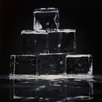 Dark background with very transparent ice cubes stacked in a pyramid