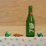 Painting of glass soda bottle with gumby figurines on polka dot table cloth