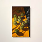 Green apples on orange table cloth with black marble poking out