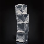 Column of 4 white origami paper boxes stacked and leaning forward