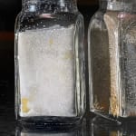 Painting of a salt and pepper shaker sitting on a bar