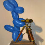Painting of blue balloon dog on top of a stack of art books
