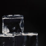 Detail of Dark background with very transparent ice cubes stacked in a pyramid
