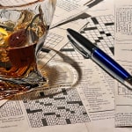 Painting of Manhattan in a glass with in-progress Crowssword Puzzles