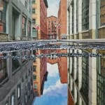 Panoramic view of Street, with a puddle in the foreground reflecting the buildings and the blue sky above.