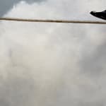 Man in business suit walking on a tightwire