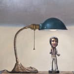 Painting of an Elvis figurine on top of a box with a desk lamp