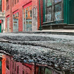 low viewpoint of a puddle on a narrow Tribeca Street