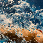 Woman in a red bikini diving through blue water