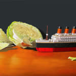 A toy replica of the HMS Titanic is placed amongst the cut up pieces of a head of iceberg lettuce.