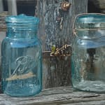 Painting of two glass jars on an old wood fence with a chain lock