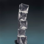 Right leaning stack of paper origami boxes before a teal and black background