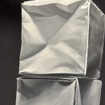 Two origami paper cube columns before black background