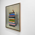Still life painting of a stack of books with a toy bird atop