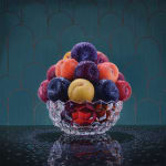Bowl of plums with water droplets