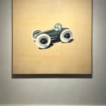 View on a painting of a boy in a race car hanging in the gallery