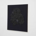 small ceramic needles sewn to a dark indigo canvas