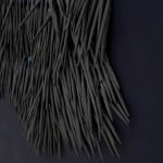 small ceramic needles sewn to a dark indigo canvas