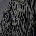 small ceramic needles sewn to a dark indigo canvas