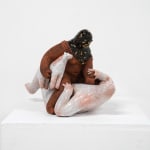 ceramic sculpture of a being sitting on top and stabbing another being