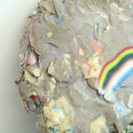 rock sculpture with frown face (rainbow)