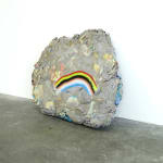rock sculpture with frown face (rainbow)