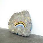 rock sculpture with frown face (rainbow)