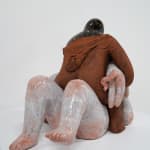 ceramic sculpture of a being sitting on top and stabbing another being