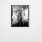 black and white photo of a woman standing in the doorway of her apartment