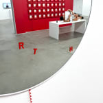 circular mirror with a red phone hanging from it