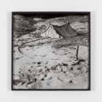 A black and white image of a tent in the desert.