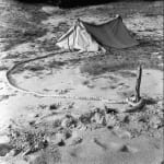 A black and white image of a tent in the desert.