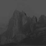 A black and white inkjet print of a mountain landscape.