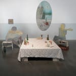 image of a mixed media installation consisting of two panels shaped and painted to depict people, posed at either end of a table covered in a floral cloth and bearing several small glasses and containers