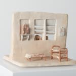 opposite side of the wall in the ceramic piece, depicting an interior with a virgin mary figurine and three small beds