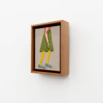 Embroidered figure holding a cigarette, wearing a knee length green skirt and a pink long sleeve top with blue flat shoes.
