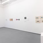 white gallery wall with small assorted artworks