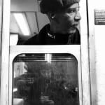 black and white photo of subway train conductor looking out the window