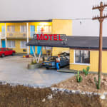 miniature diorama by Abigail Goldman of a woman bleeding on the ground in the parking lot of a motel
