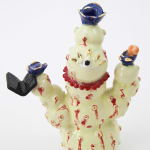 Jen Dwyer sculpture - beige cactus with red accents and one eyeball at center, holding black laptop and other accessories