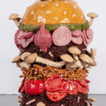 Lindsey Lou Howard sculpture of giant burger with onions, tomatoes, mushrooms, all in excessive amounts