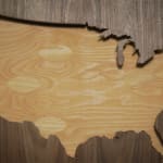 Wooden silhouette of the United States surrounded by darker wood