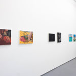 white gallery wall with paintings of various sizes
