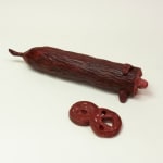 Stephen Morris "Salami" ceramic sculpture of realistic red salami with two pieces cut out revealing a face