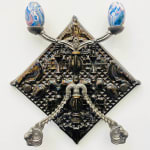 silver candelabra hung on a white wall holding two multicolored eggs