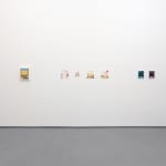 white gallery wall with small assorted artworks